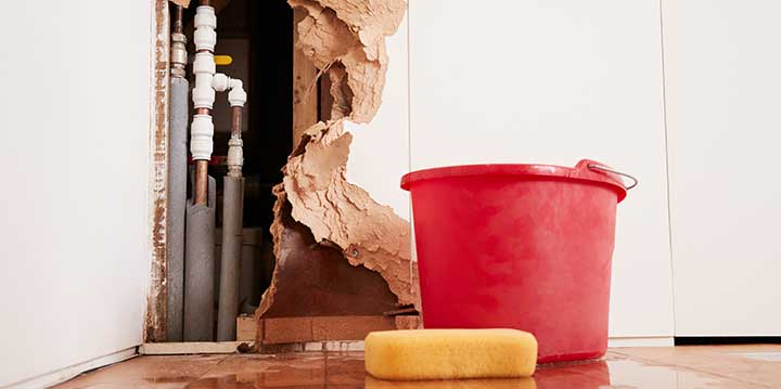 Image of drywall ripped apart to expose pipes