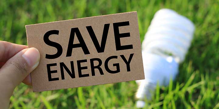 Hand holding a Save Energy sign